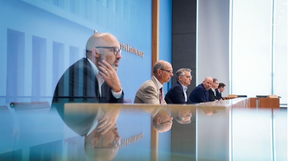 Herbstgutachten führender Wirtschaftsforscher sagt Rezession voraus Fünf führende Wirtschaftsforscher sitzen nebeneinander bei der Bundespressekonferenz zum Thema Rezession