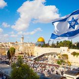 Eine Israelflagge mit Tel Aviv im Hintergrund.