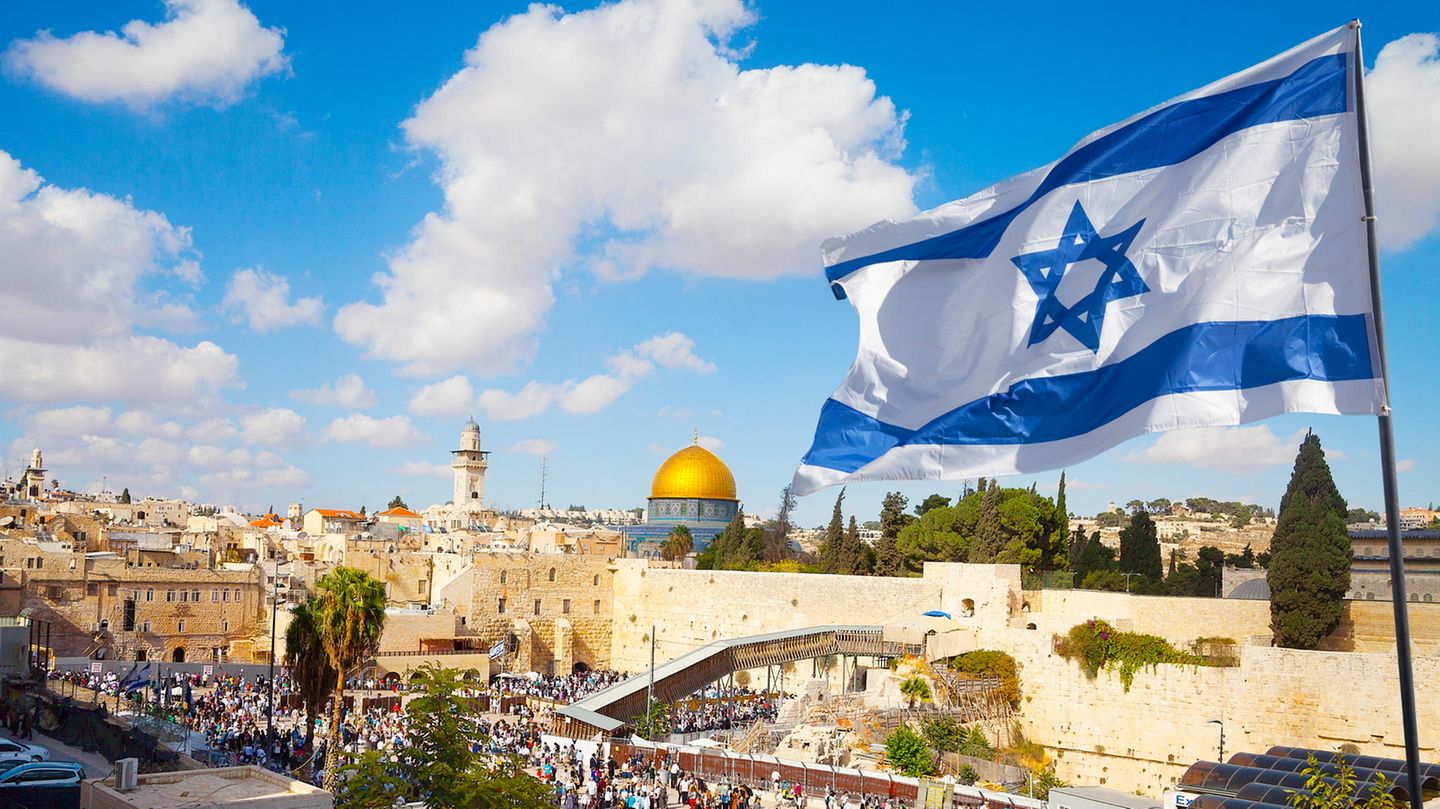 Eine Israelflagge mit Tel Aviv im Hintergrund. Eine Israelflagge mit Tel Aviv im Hintergrund.