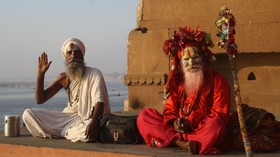 Yoga Zwei indische Männer sitzen in traditioneller Kleidung auf dem Boden