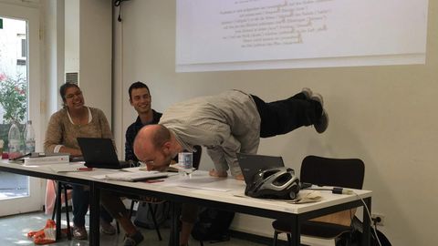 Dozent führt eine Yoga-Pose auf einem Tisch vor