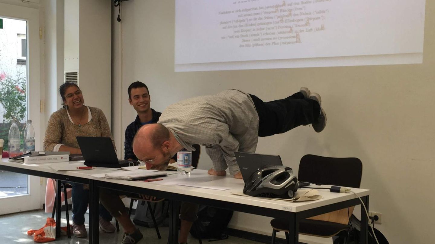 Instructor demonstrates a yoga pose on a table