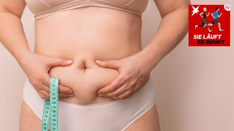 Eine Frau hält ihre Speckfalten am Bauch