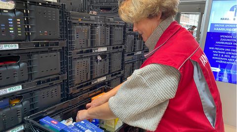 Tafel-Mitarbeiterin Tina Peters räumt Lebensmittel in Kisten
