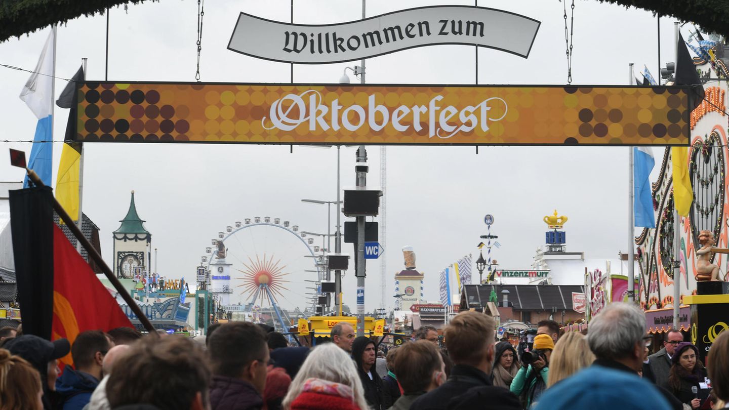 Unter einem Schild "Willkommen zum Oktoberfest" strömen Besuchermassen auf die Theresienwiese