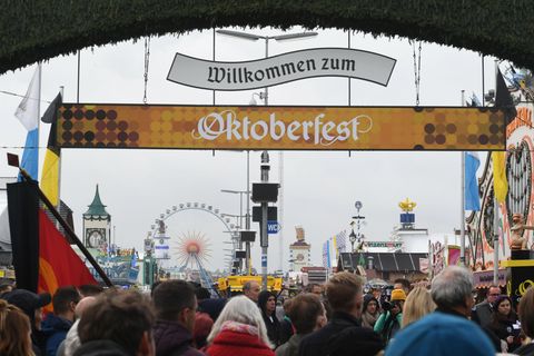 Unter einem Schild "Willkommen zum Oktoberfest" strömen Besuchermassen auf die Theresienwiese