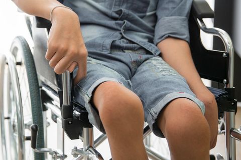 Ein an Kinderlähmung erkrankter Junge im Rollstuhl