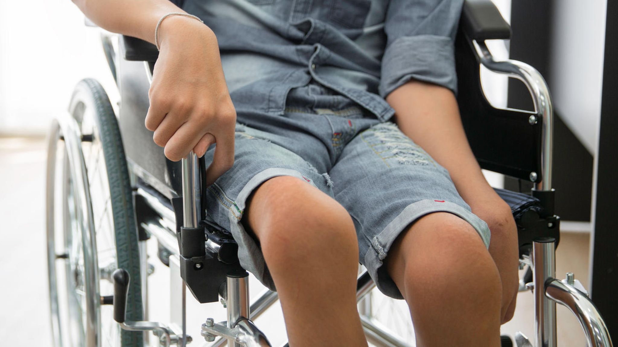 Ein an Kinderlähmung erkrankter Junge im Rollstuhl