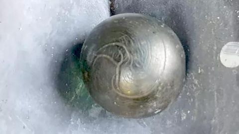 Metallische Kugel leuchtet grünlich