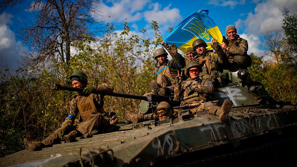 Ukrainische Soldaten halten eine ukrainische Fahne