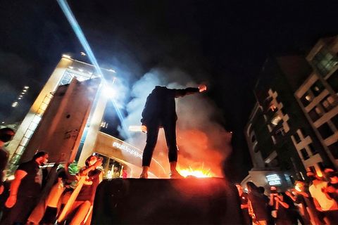 Junge Frauen und Männer demonstrieren gegen das iranische Regime