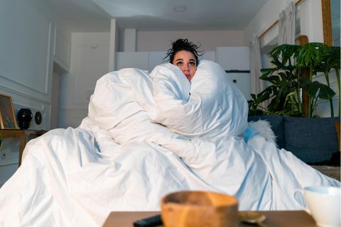 Eine Frau, eingemummelt in eine dicke Decke