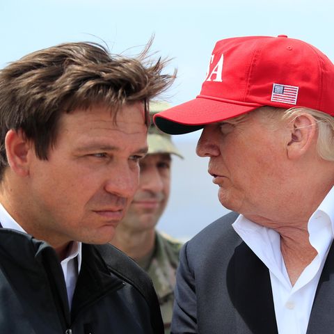 Ron DeSantis hört angestrengt zu, was Donald Trump ihm ins Ohr sagt
