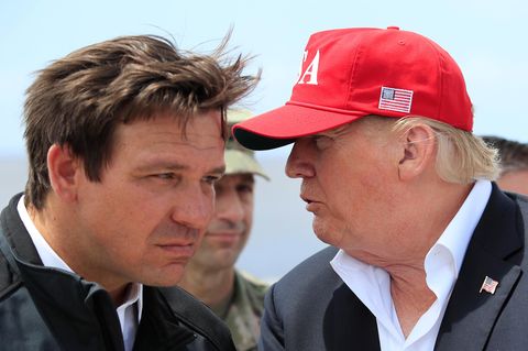 Ron DeSantis hört angestrengt zu, was Donald Trump ihm ins Ohr sagt