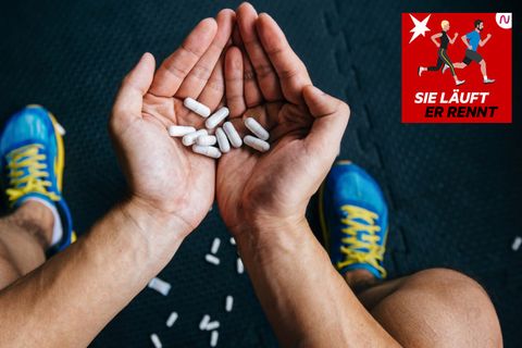 Ein Sportler hält weiße Tabletten in den Händen