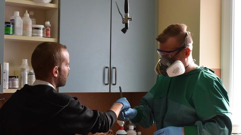 Thanatopraktiker Phillip Berger übergibt seinem Praktikanten Mario Meyer eine Pinzette