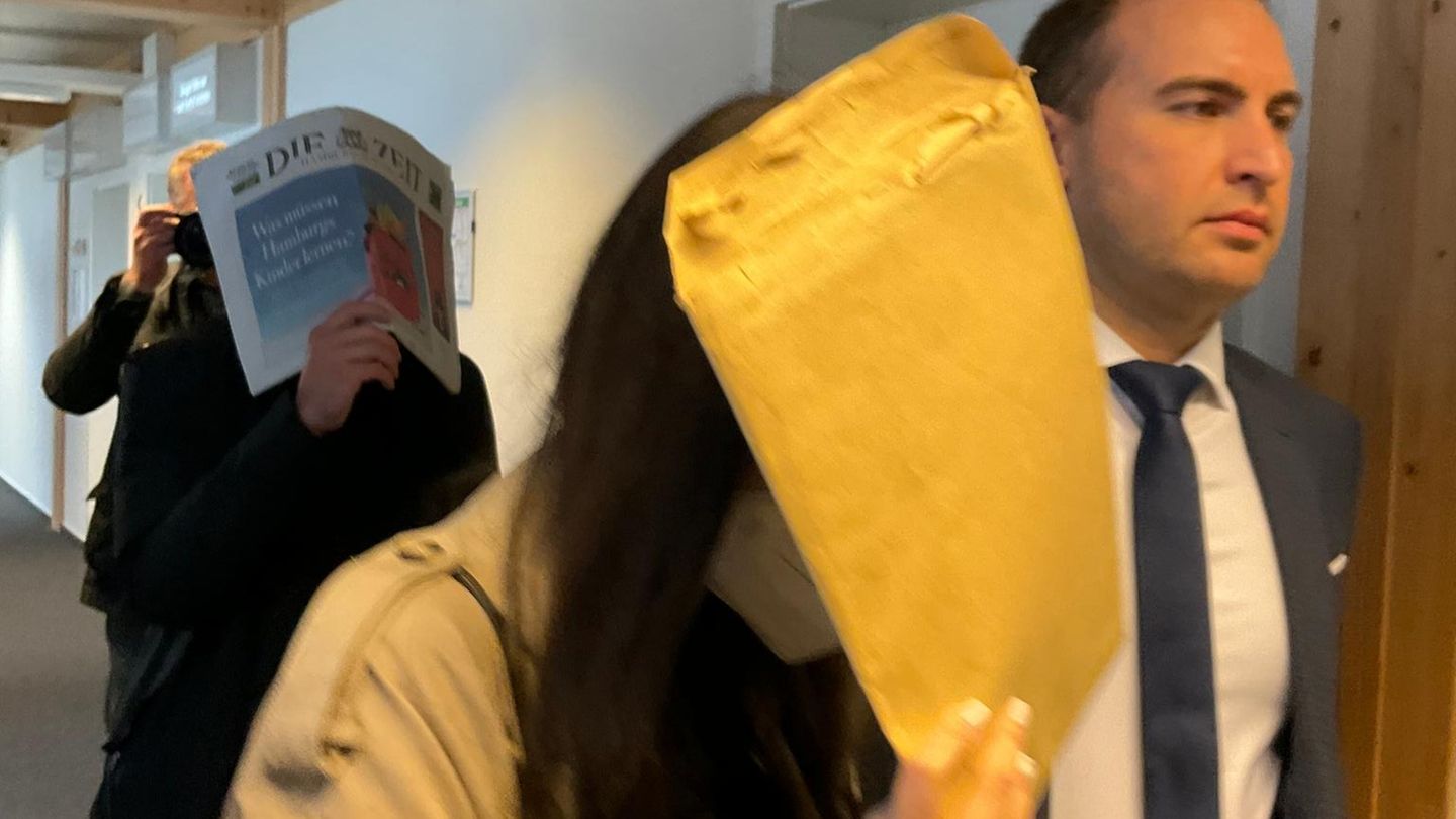 Die Angeklagten Anna L. und Samuel D. verstecken ihre Gesichter beim Gang durch den Gerichtsflur im Amtsgericht Lübeck.