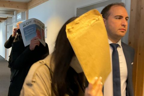 Die Angeklagten Anna L. und Samuel D. verstecken ihre Gesichter beim Gang durch den Gerichtsflur im Amtsgericht Lübeck.