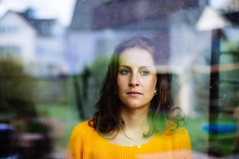 Eine Frau schaut traurig aus dem Fenster.