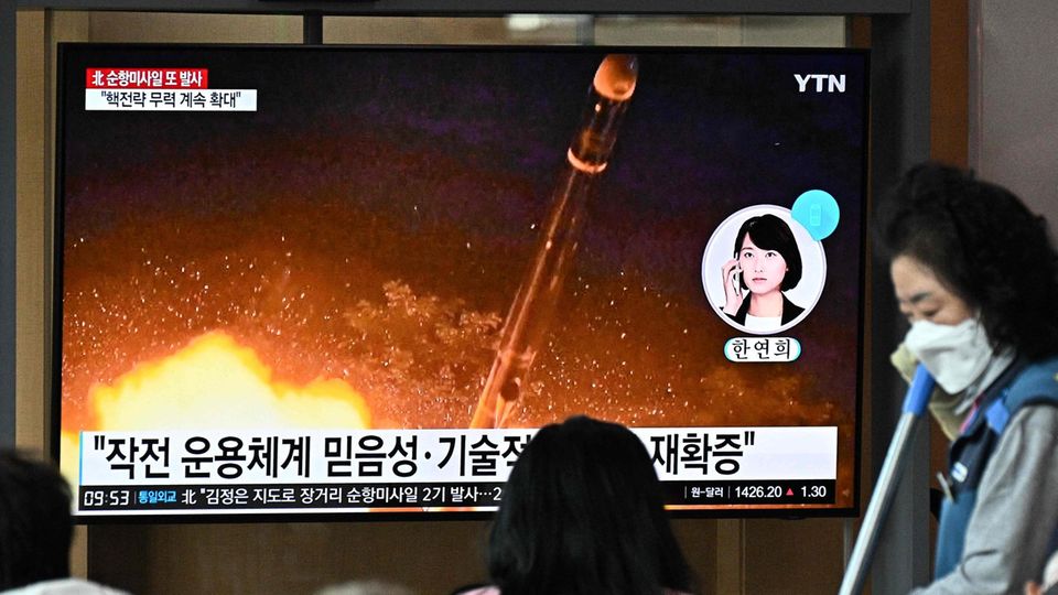 Nordkorea Raketentest Ein schwarzhaariges Mädchen sitzt vor einem Fernseher, auf dem eine Rakete startet. Auf dem Bildschirm sind koreanische Zeichen