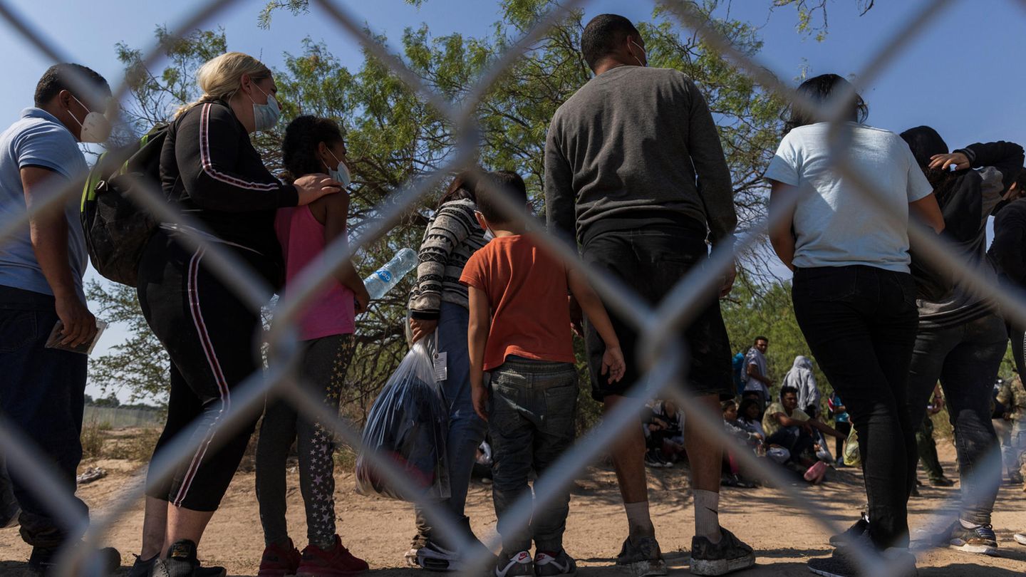 Flüchtlinge aus Venezuela stehen in den USA hinter einem Zaun