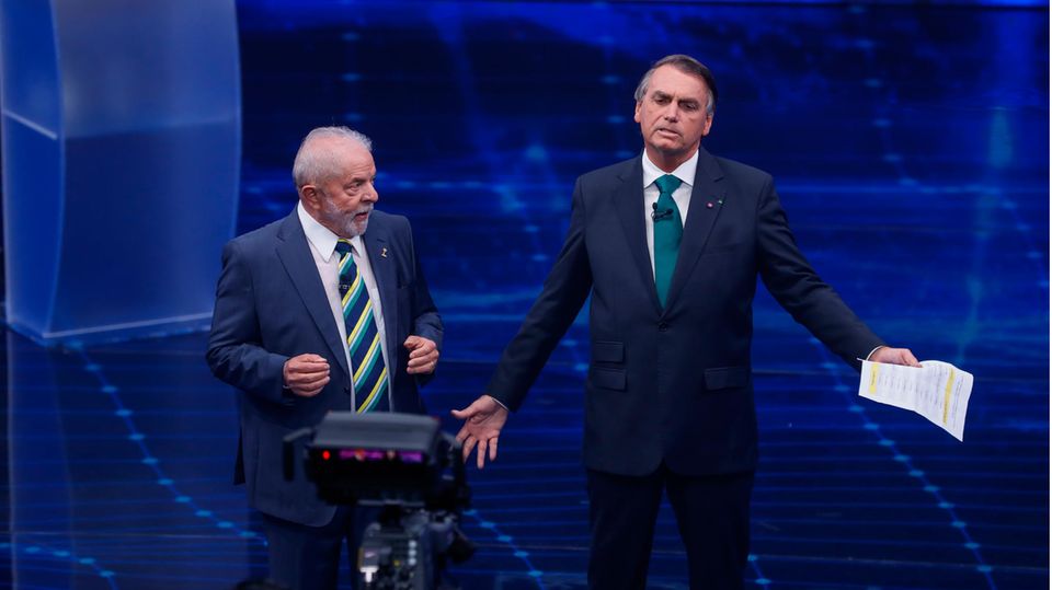 Präsidentschaftswahl in Brasilien: Brasiliens ehemaliger Präsident Luiz Inacio Lula da Silva (l.), der erneut für das Amt kandidiert, steht neben Jair Bolsonaro, Präsident von Brasilien, in einer Präsidentschaftsdebatte im Fernsehsender Bandeirantes gegenüber Brasiliens ehemaliger Präsident Luiz Inacio Lula da Silva (l.), der erneut für das Amt kandidiert, steht neben Jair Bolsonaro, Präsident von Brasilien, in einer Präsidentschaftsdebatte im Fernsehsender Bandeirantes gegenüber