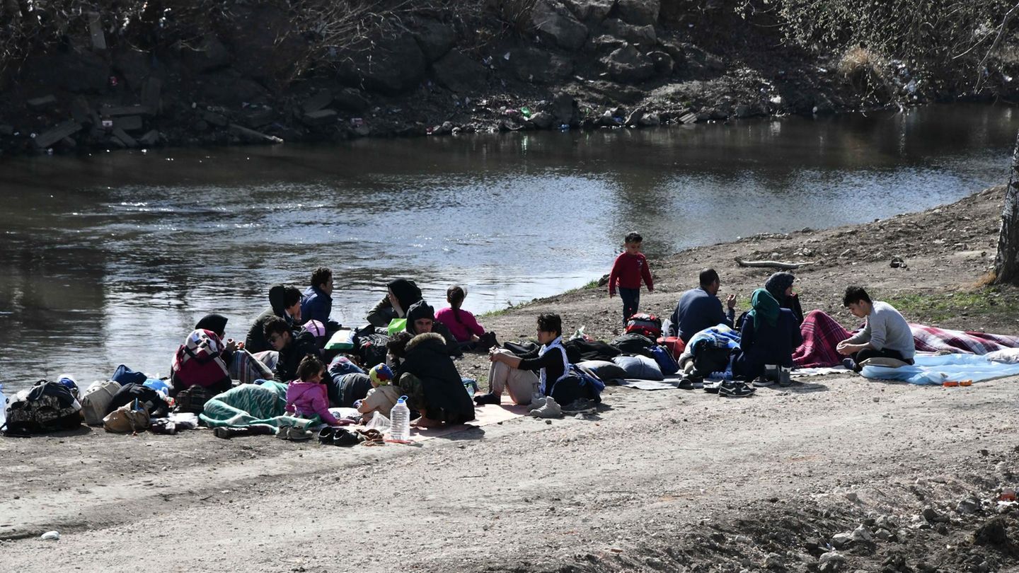 Flüchtlinge sitzen an einem Fluss in der Nähe der Grenze zwischen Griechenland und der Türkei