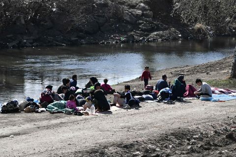 Flüchtlinge sitzen an einem Fluss in der Nähe der Grenze zwischen Griechenland und der Türkei