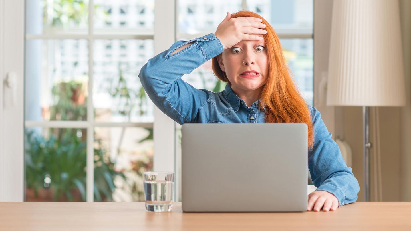 Eine verzweifelte Frau vor dem Laptop
