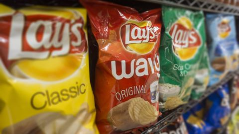 Symbolfoto für Balenciaga-Handtasche: Chipstüten der Marke Lays stehen in einem Supermarktregal