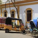 Rikschas stehen vor einem Gebäude im französischen Kolonialstil