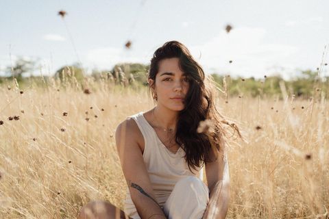 Rebecca Chelbea sitzt in einem Feld
