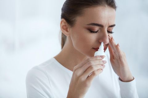 Eine Frau benutzt Nasenspray