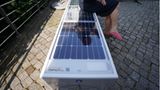 Eine Frau sitzt auf einer Solar-Parkbank in Hamburg