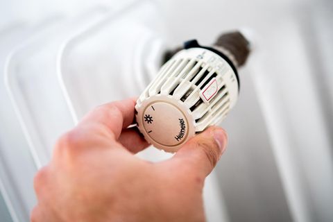 : Ein Mann dreht in einer Wohnung am Thermostat einer Heizung. (zu dpa: "«Wirtschaftsweise»: Mieter brauchen Anreize zum Energiesparen") Foto: Hauke-Christian Dittrich/dpa +++ dpa-Bildfunk +++