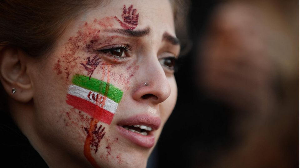 A young protester, with the Iranian flag on her cheek, in Paris