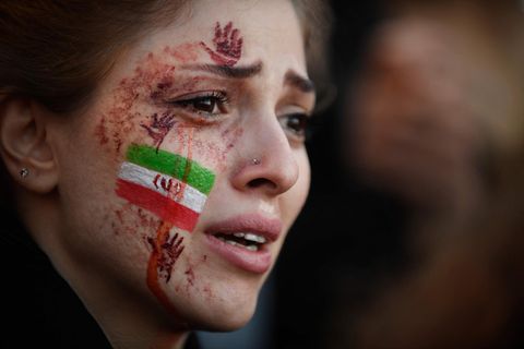 Eine junge Demonstrantin, mit iranischer Flagge auf der Wange, in Paris