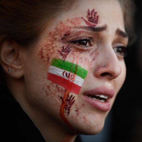 Eine junge Demonstrantin, mit iranischer Flagge auf der Wange, in Paris
