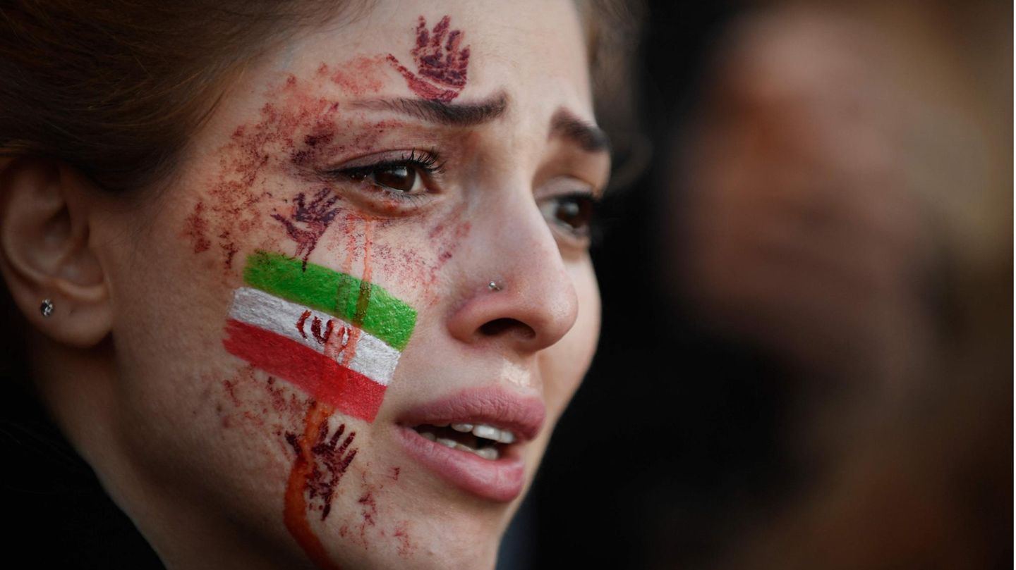 Proteste im Iran: Eine junge Demonstrantin, mit iranischer Flagge auf der Wange, in Paris Eine junge Demonstrantin, mit iranischer Flagge auf der Wange, in Paris