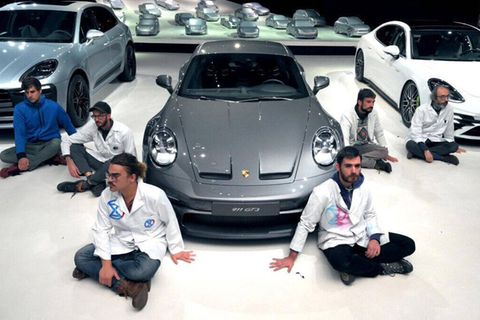 Mehrere Aktivisten klebten sich bei Porsche fest.