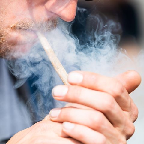 Ein Mann zündet sich einen Joint an