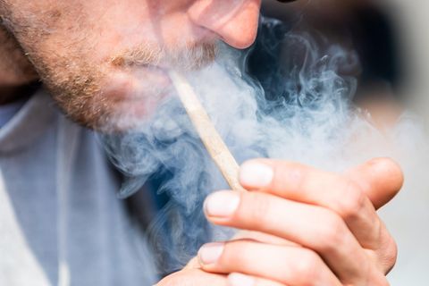 Ein Mann zündet sich einen Joint an