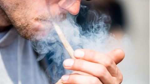Ein Mann zündet sich einen Joint an