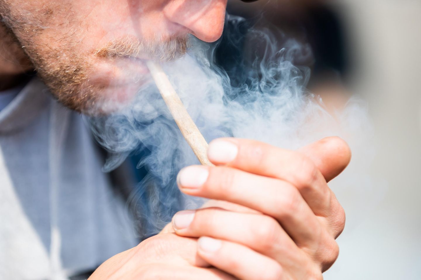 Ein Mann zündet sich einen Joint an