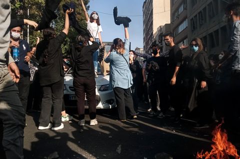 Iran, Teheran: Eine Frau steht während einer Demonstration auf einem Auto