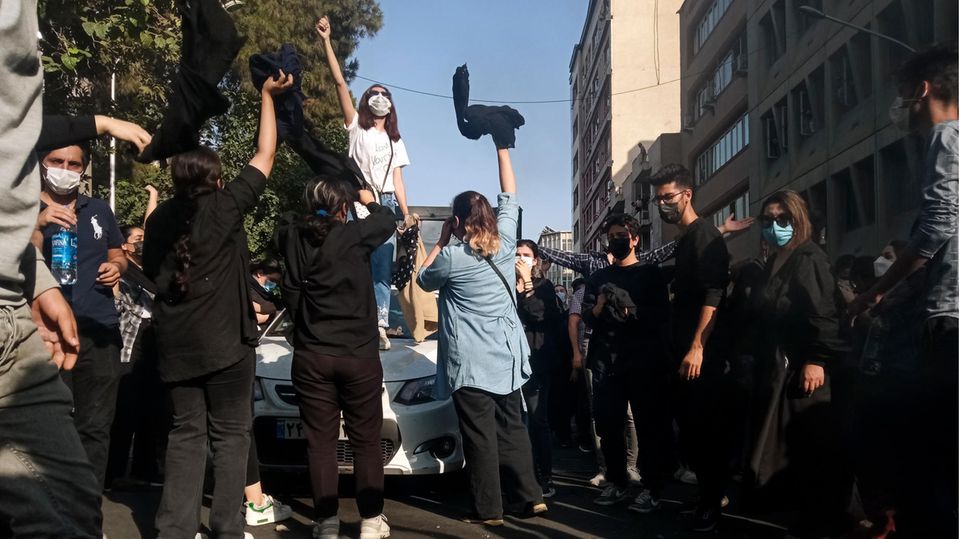 Iran, Teheran: Eine Frau steht während einer Demonstration auf einem Auto