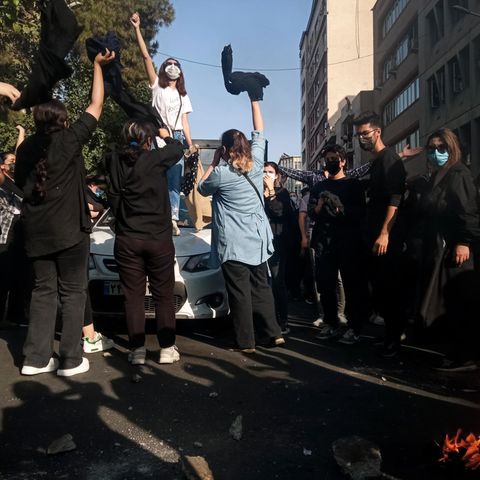 Iran, Teheran: Eine Frau steht während einer Demonstration auf einem Auto