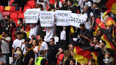 Fußball-Fans zeigen im Stadion Banner, auf denen für Menschenrechte in Katar protestieren