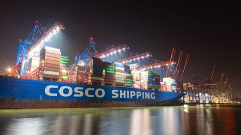 Ein Containerschiff von Chinas Staatskonzern Cosco bei Nacht im Hamburger Hafen