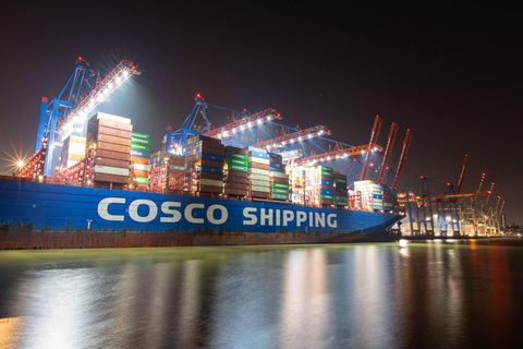 Ein Containerschiff von Chinas Staatskonzern Cosco bei Nacht im Hamburger Hafen